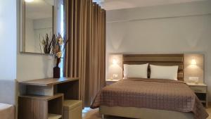 a bedroom with a bed and a table with a mirror at Vasiliki House in Sarti