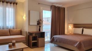 a bedroom with a bed and a couch and a window at Vasiliki House in Sarti