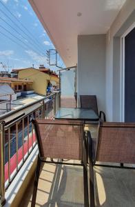 a balcony with two chairs and a table on a building at Vasiliki House in Sarti