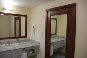 a bathroom with two sinks and two mirrors at Hotel Tehuacan Plaza in Tehuacán +33 photos