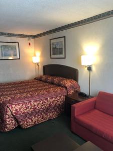 a hotel room with a bed and a couch at Fairborn Hotel and Inn in Fairborn