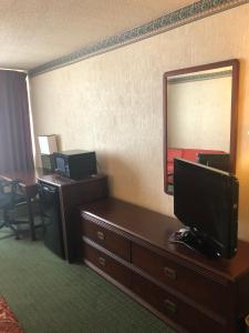 a hotel room with a television and a mirror at Fairborn Hotel and Inn in Fairborn
