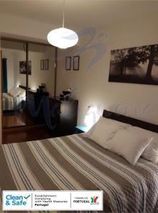 a bedroom with a bed and a large light fixture at Maligueira Apartment in Leiria