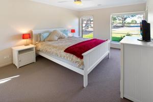 a white bedroom with a bed and a window at Toonalook Retreat in Paynesville