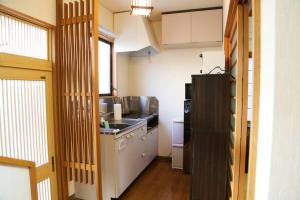 a small kitchen with a sink and a refrigerator at Tsukuyomi Chuodori in Kanazawa