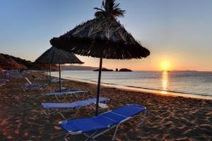 a group of chairs and umbrellas on a beach at Thalia Hotel in Palekastron