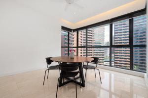 a table and chairs in a room with a large window at Cendana by Plush in Kuala Lumpur