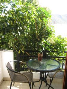 une table en verre et deux chaises sur la terrasse dans l'établissement Thalia Hotel, à Palekastro