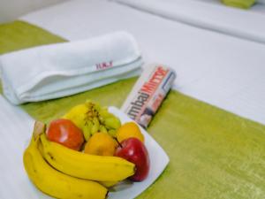 a plate of bananas and apples on a table at Hotel Alfa Heritage in Mumbai