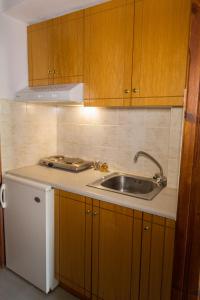 a kitchen with wooden cabinets and a sink at Filoxenia Studios 1 in Palaiochora