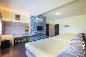 a bedroom with a bed and a desk and a tv at White Sand Beach 32 in Green Island