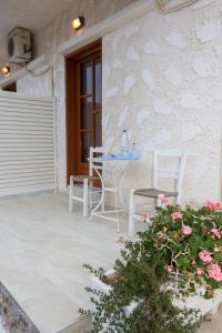 a patio with a table and chairs and flowers at Filoxenia Studios 1 in Palaiochóra