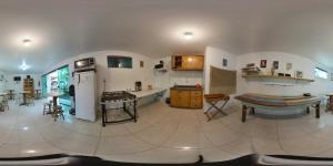 a large kitchen with a counter and a table in it at Pousada Bem te vi in Garopaba