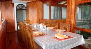 a dining room with a long table and chairs at Bezel Bungalow Nuwara Eliya in Nuwara Eliya