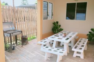 a patio with a picnic table and a grill at Little B house in Ban Tao Than