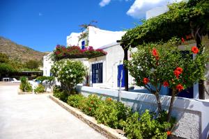 a group of white buildings with flowers on them at Paradise Apartments Studios in Mylopotas