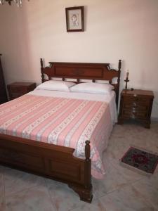 a bedroom with a bed with a striped blanket and a table at Casa Dolce Casa in Reggio di Calabria