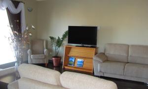 uma sala de estar com 2 sofás e uma televisão de ecrã plano em Villa Da Madalena em Madalena