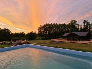 Blick auf den Pool bei Sonnenuntergang mit einem Zelt in der Unterkunft Pennu Villa in Vahtra