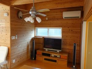 a living room with a television and a ceiling fan at machiyado Kuwanajuku Honmachi 10 in Kuwana