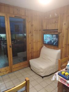 een woonkamer met een witte bank en een tv bij OURSONS 1 in Morillon