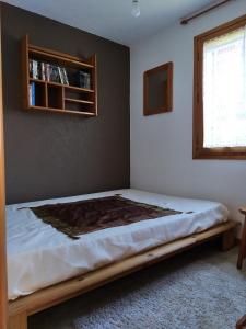 een slaapkamer met een bed in een kamer met een raam bij OURSONS 1 in Morillon