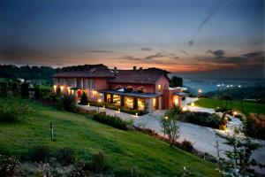 a large house on a hill at night at Relais Villa D'Amelia in Benevello