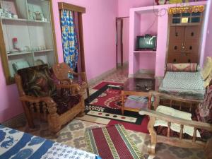 a living room filled with furniture and a tv at Dreams River view Homestay Coorg in Kushālnagar