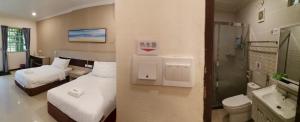 a hotel room with two beds and a bathroom at Hemingway Cottage 海明威度假屋 in Semporna