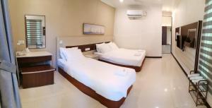 a hotel room with two beds and a bathroom at Hemingway Cottage 海明威度假屋 in Semporna