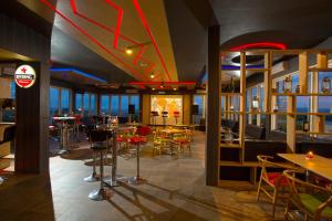 a restaurant with tables and chairs and a bar at Ascent Hotel & Cafe Malang in Malang