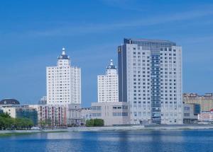 a group of tall buildings in a city with water at Shangri-La Manzhouli in Manzhouli