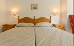 a bedroom with a large bed with two night stands at Hotel La Glorieta in Baños de Montemayor