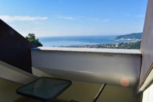a view of the ocean from a balcony with a chair at B&B Villa Paola in Savona
