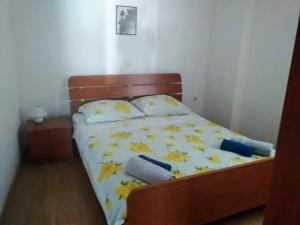 a small bedroom with a bed with yellow sheets and pillows at Apartmani Maja in Pag