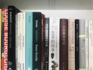 a row of books on a book shelf at Zhe·Yi Boutique Guesthouse in Beijing