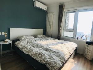 a bedroom with a large bed and a window at Zhe·Yi Boutique Guesthouse in Beijing