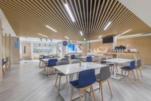 a cafeteria with tables and chairs and a counter at Holiday Inn Express Shanghai Gubei, an IHG Hotel in Shanghai