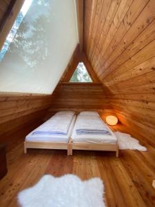 Cama en habitación de madera con ventana en I Larici Camping Lodge, en Ossana