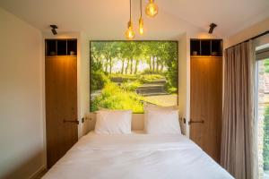 a bedroom with a bed with a large window at 't Goed ter Fintele in Lo-Reninge