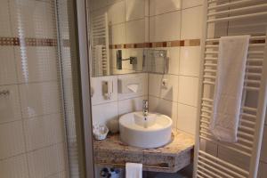 een badkamer met een wastafel en een douche bij Work & Travel - KRAL Hotels Erlangen in Erlangen