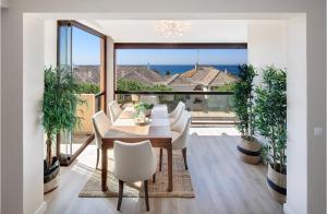 a dining room with a table and chairs and a large window at AMAZING DUPLEX NEXT TO THE BEACH IN MARBELLA in Marbella
