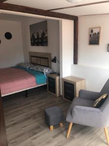 ein Schlafzimmer mit einem Bett, einem Stuhl und einem Sofa in der Unterkunft PARADISE FUERTEVENTURA in Morro del Jable