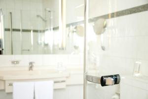 ein Bad mit einer Glastür mit einem Waschbecken in der Unterkunft Etzhorner Krug in Oldenburg