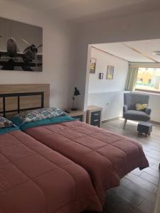 1 dormitorio con 1 cama grande y 1 silla en PARADISE FUERTEVENTURA, en Morro del Jable