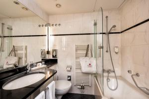 ein Bad mit einem Waschbecken, einem WC und einer Dusche in der Unterkunft Best Western Premier Parkhotel Bad Mergentheim in Bad Mergentheim