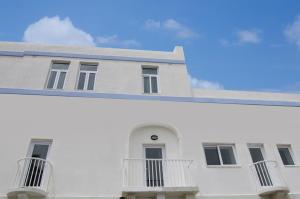 a white building with balconies on the side of it at Cresta Beach Studios in St. Julianʼs