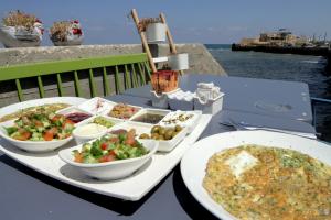 een tafel met twee borden eten en een pizza bij Nzar Khoury for Hosting in Akko