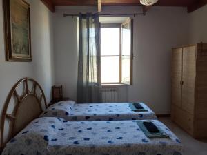 2 camas num quarto com uma janela em Enjoy Sunset em Colle Massari