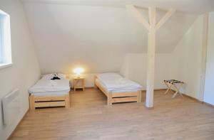 Habitación con 2 camas y una cruz en la pared. en Resort Erich en Sázava